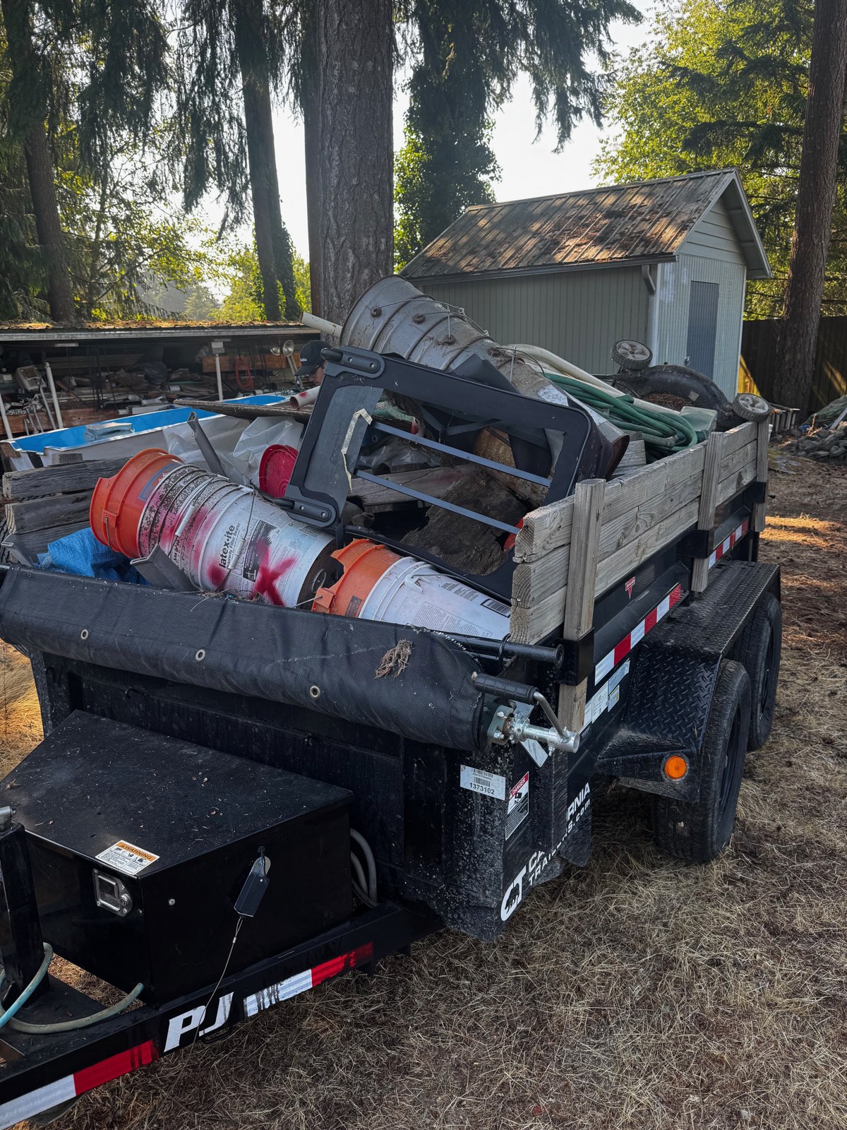 PJ 5x10 dump trailer loaded with debris and ready to haul